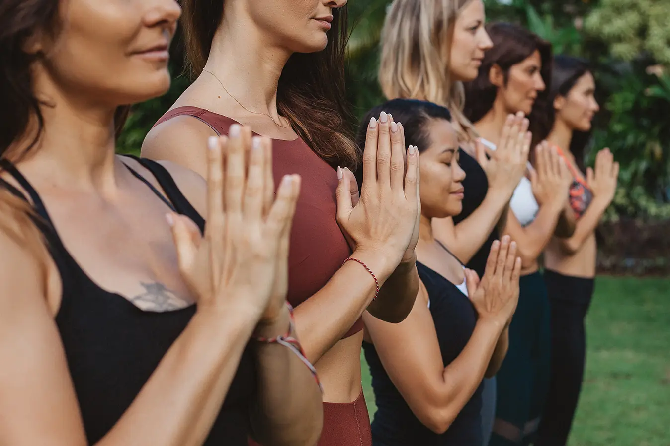 Students standing in anjali mudra in the garden