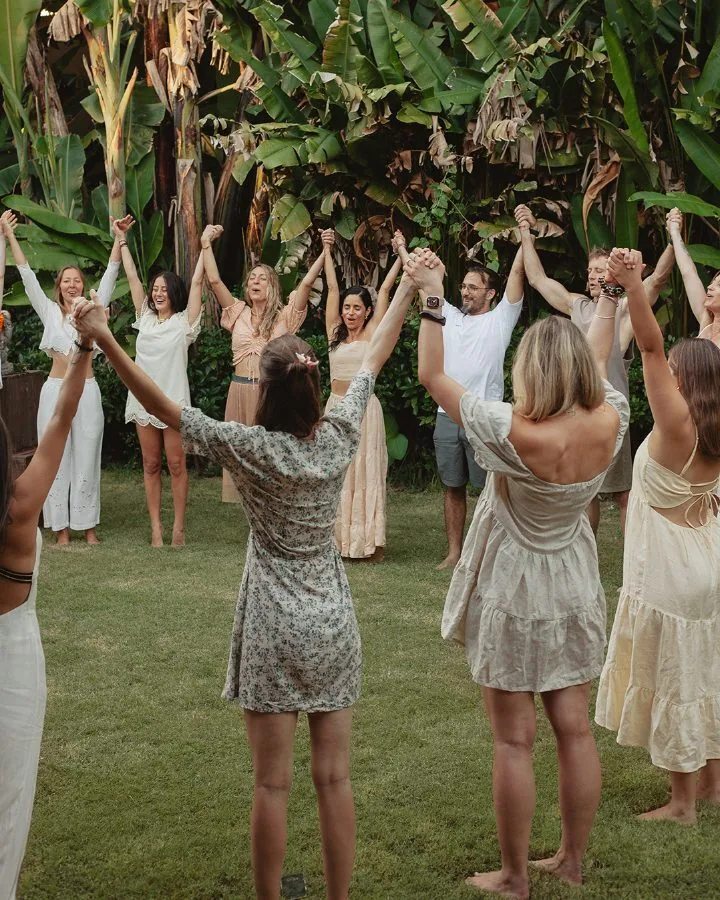 The group in a circle with hands raised in celebration