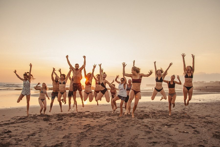 The group jumping on the beach at sunset