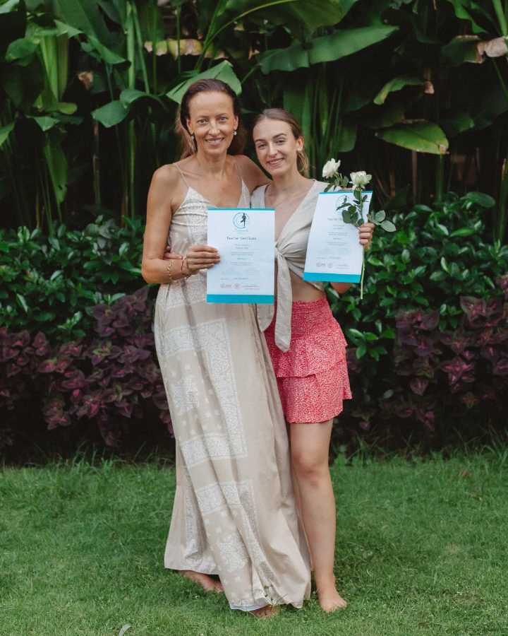 Two graduates holding their certificates