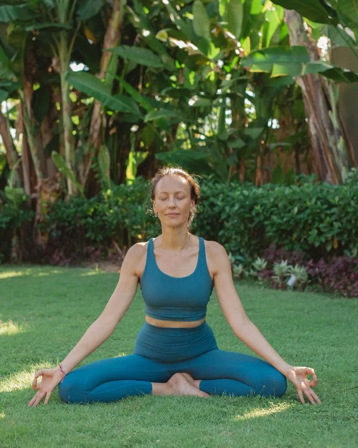 A woman in seated meditation in the garden