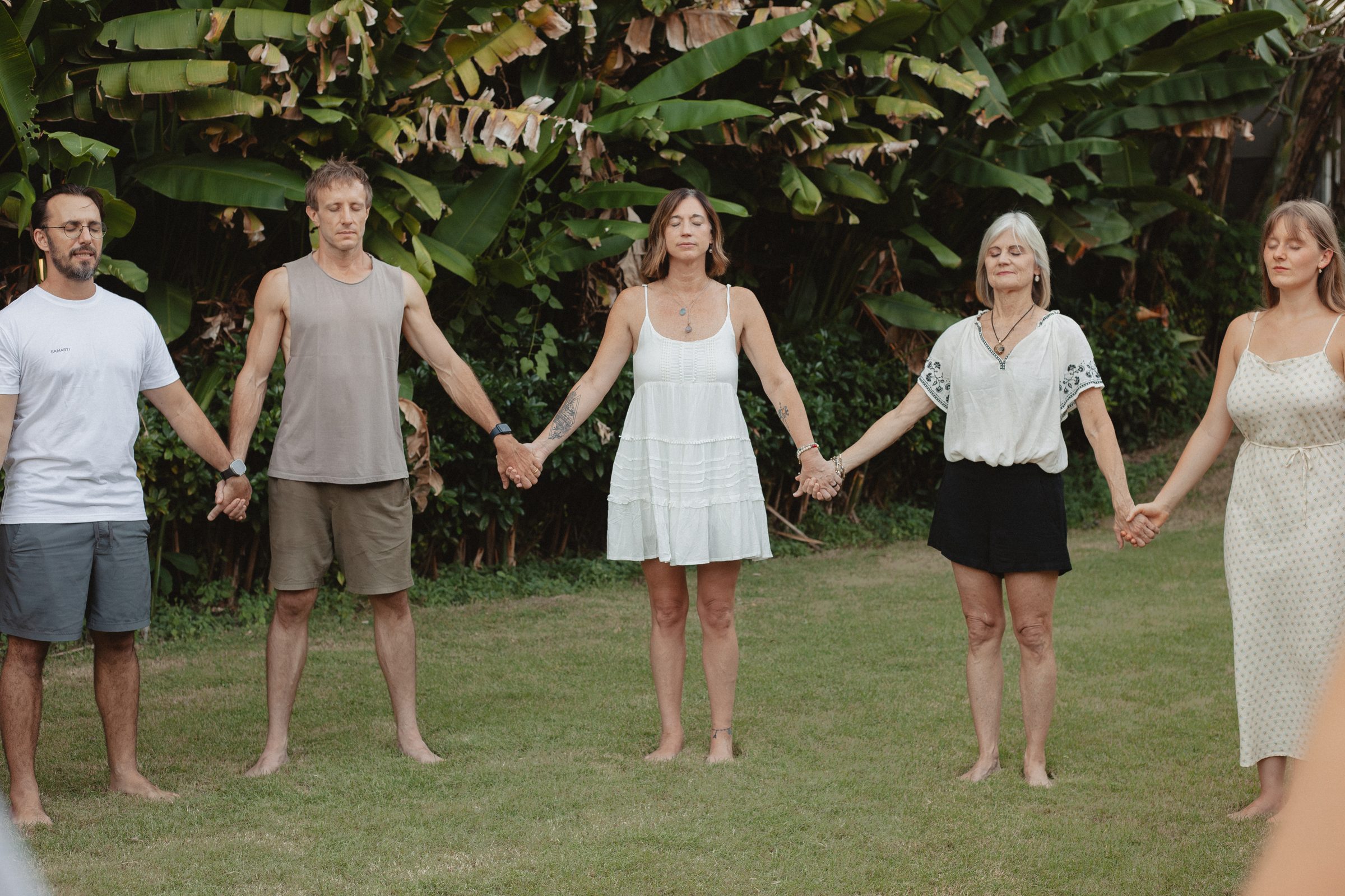 Samasti graduates standing in a circle in the garden holding hands