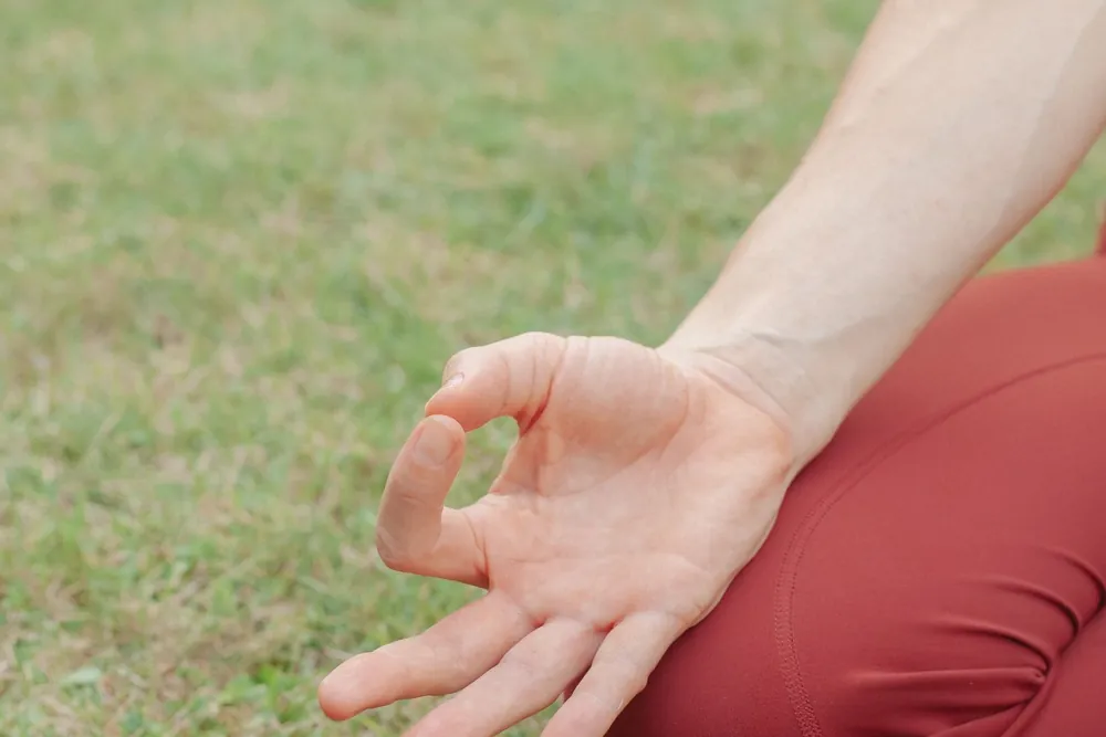 A hand resting on the knee in gyan mudra