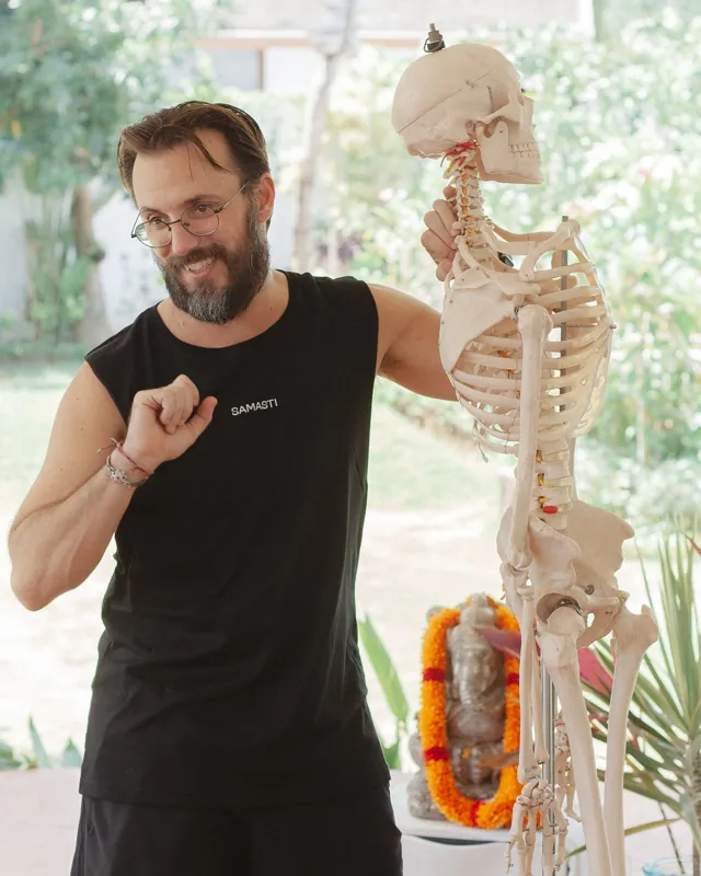 Sean Goldberg teaching anatomy with a full size skeleton in the Samasti shala