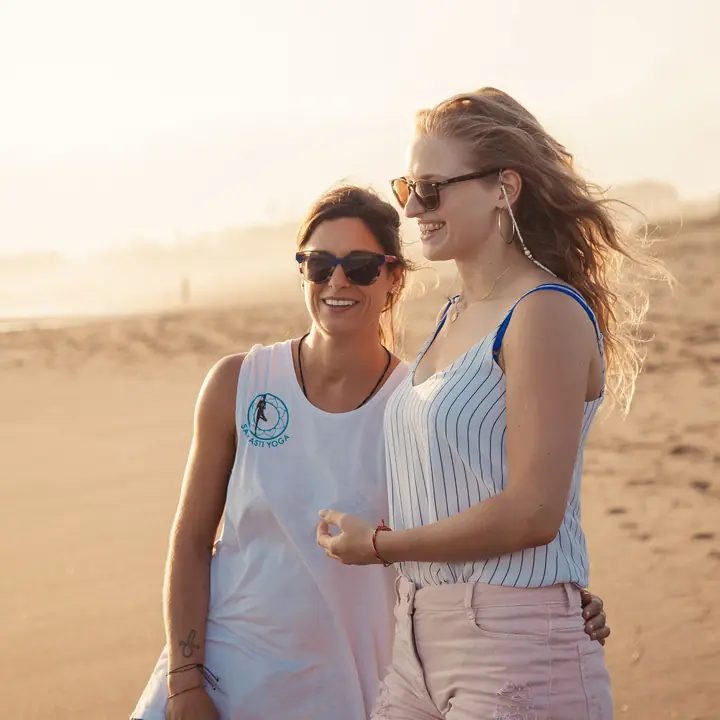 Two students on the beach at sunset